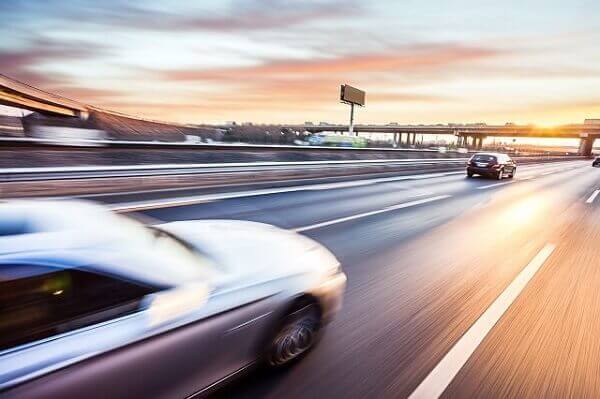 car driving into sun on freeway